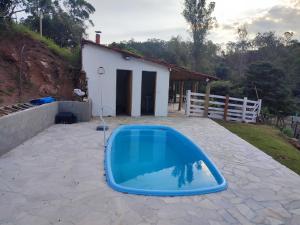 库尼亚Casa de campo com piscina a 2 min de cunha的一座带房子的庭院中的蓝色游泳池