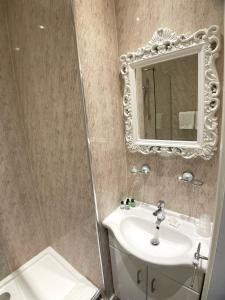 德比The Lawns Hotel的一间带水槽和镜子的浴室