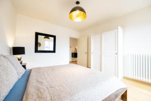 苏黎世Zurich downtown dream的一间白色卧室,配有一张床和一个衣柜