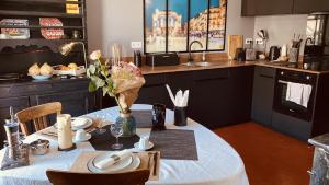 蒙彼利埃Casa Roma Montpellier Bed&Breakfast chambres d hôte的厨房配有带白色桌布的桌子