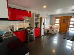 拉塞雷纳Amplia Casa en Condominio的厨房配有红色橱柜和不锈钢用具