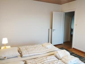 埃斯比约(Id022) Strandby Kirkevej 270 1 th的白色客房的两张床,配有灯