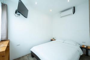 雅科Hotel Bamboo的卧室配有一张床,墙上配有电视。
