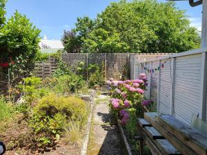 波尔多Chambre privée chez l'habitant en colocation dans agréable maison avec jardin - A private room in a shared house with garden的一个带木凳和鲜花的花园