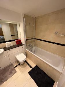 伦敦Room with Private Bathroom Royal Victoria Excel O2 Arena London的浴室配有卫生间、浴缸和水槽。