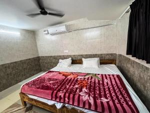 蓬蒂切里Royal Grand Residency的一间卧室配有一张带红色毯子的床