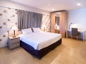 呵叻Crystal Resort Korat的一间卧室配有一张大床和一张书桌