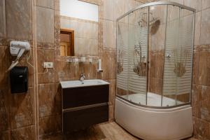 拉姆尼库沃尔恰Hotel Royal的带淋浴和盥洗盆的浴室