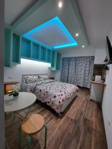 卡梅拉诺IL CUORE DEL CONERO - CASALE CON PISCINA, Natura e Relax的一间卧室设有一张床铺和一张桌子,拥有蓝色的天花板