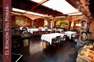 雷西斯膝西亚Del Pomar Hotel Boutique的一间餐厅,房间内设有白色的桌椅