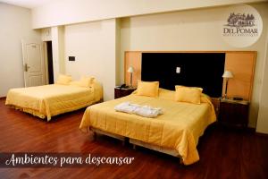 雷西斯膝西亚Del Pomar Hotel Boutique的酒店客房带两张带黄床单的床