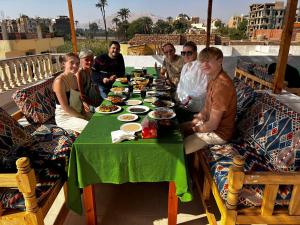 卢克索Mikhaila Guest House的一群人坐在桌子旁吃着食物
