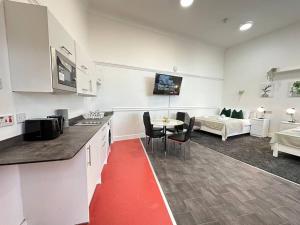 伯明翰Modern 3-Bed Haven in West Midlands!的厨房以及带桌子和沙发的客厅。