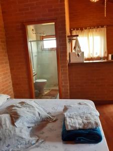 贡萨尔维斯Chalé Recanto Lobo Guará的一间卧室经过改造,设有一张床和一间浴室