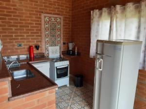 贡萨尔维斯Casa Recanto Lobo Guará的厨房配有白色冰箱和炉灶。