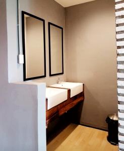 乌隆他尼拉马里拉旅舍的浴室设有白色水槽和两面镜子