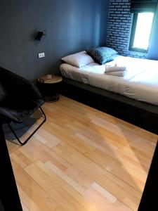 乌隆他尼拉马里拉旅舍的一间卧室配有一张床和一把椅子,铺有木地板