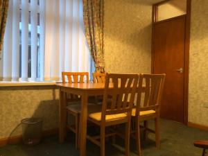 布莱克浦Blackpool Serviced Apartments的窗户客房内的一张木桌和椅子