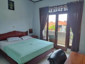 八丹拜塞拉吉旅馆的一间卧室设有一张床和一个大窗户