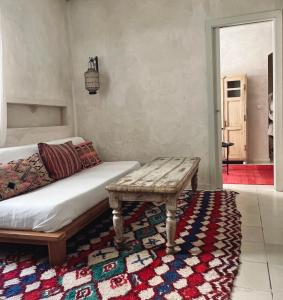 塔里法卡纳万恩公寓酒店的一间铺在地毯上的房间,配有床和长凳