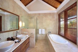 乌鲁瓦图卡尔玛坎德拉酒店的浴室配有两个盥洗盆和浴缸。