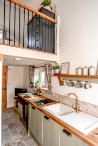 Temple EwellWoodman's Cottage的一个带水槽和楼梯的厨房