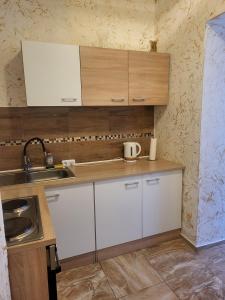 阿尔滕堡Angel的小厨房配有白色橱柜和水槽