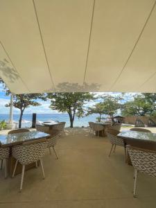 Lapu Lapu CityThe Beach Suite at The Mactan Newtown的一个带桌椅的空置露台,享有海景