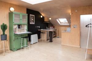 伦敦Stunning studio loft in Brixton, London的厨房配有旧绿色橱柜和柜台。