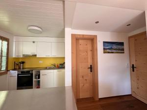 茨韦西门Chalet Solaria 2 bedrooms with mountain and garden view的一间厨房,配有白色的橱柜和一扇开放式门
