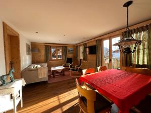 茨韦西门Chalet Solaria 2 bedrooms with mountain and garden view的一间带红色桌子的用餐室和一间客厅