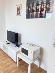 科隆Ferienwohnungen in Köln2201的一间带微波炉和电视的客厅