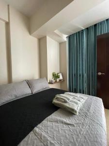 Lapu Lapu CityThe Beach Suite at The Mactan Newtown的一间卧室设有一张床和一个大窗户