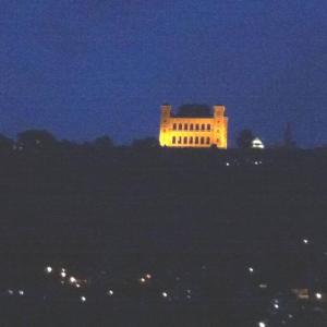 塔那那利佛Au coeur de Tana, vue sur le Palais de la Reine, en securité的一座建筑在晚上点亮,灯亮着