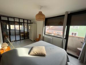 伊苏瓦尔L’appartement du bonheur的一间卧室设有一张床和一个大窗户