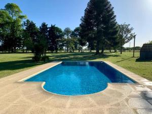 埃拉斯将军镇La Rosada Casa de Campo的绿树成荫的蓝色游泳池