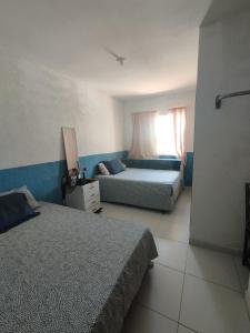 伊比拉奎拉Recanto Casa SOL的一间卧室设有两张床和窗户。
