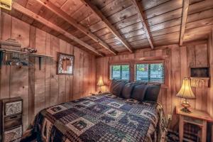 鲁伊多索Knotty Pine: A Cute Ruidoso Classic with a Private Hot Tub!的小木屋内一间卧室,配有一张床