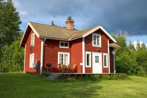 法伦Scoutstugan & Bagarstugan的草场上的一个红色小房子