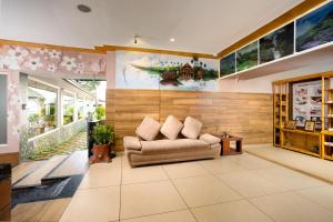 AnachalStar Emirates Luxury Resort and Spa, Munnar的客厅配有沙发和墙上的绘画