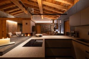 IrschenChalet ORUS - Tirol Kärnten的一间带木制天花板的厨房和一间客厅