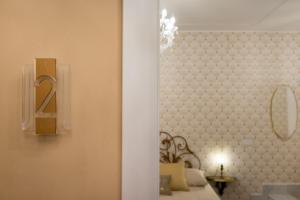 阿尔盖罗Casa dei Liuti的一间设有一张挂有墙上标志的床的房间