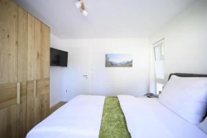奥巴拉马高Ferienwohnung Am Kofel的卧室配有一张白色大床和电视。