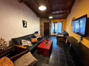 内科切阿Casa hasta 11 personas的客厅配有黑色真皮沙发和桌子