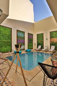 非斯Darif's Riad & Spa的一个带椅子和窗户的大型游泳池