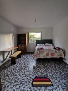 孔吉利奥Refugio Kiñeco的一间卧室配有一张床、一张桌子和一张长凳