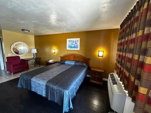 圣贝纳迪诺朝阳公园旅馆&套房的一间卧室,卧室内配有一张床和一把椅子