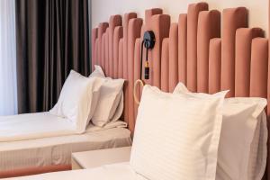 坎普朗莫道尼斯D&D Relax SPA Bucovina的配有白色枕头的床的酒店客房