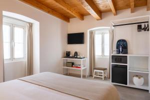 埃尔瓦斯Azinheira Suites Townhouse - Alojamento Turístico的一间卧室配有一张床和一张带微波炉的书桌