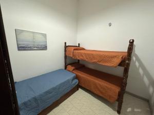 巴拉德尔楚Casa grande 3 dormitorios playa alvorada的客房设有两张双层床和一张图片。